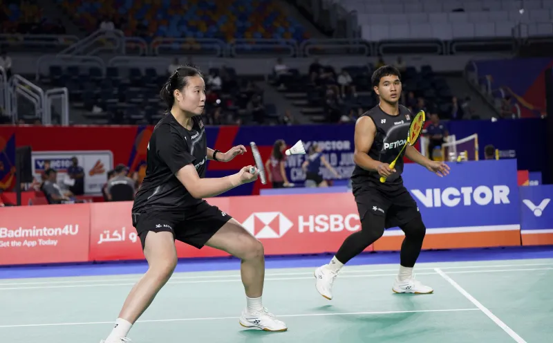Badminton rackets and a shuttlecock beside a court
