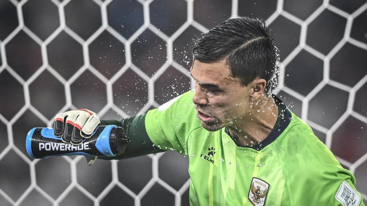 Goalkeeper gloves and a football on a pitch