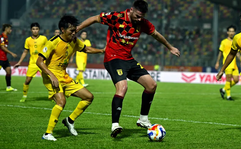 A football on the grass beside a stadium touchline