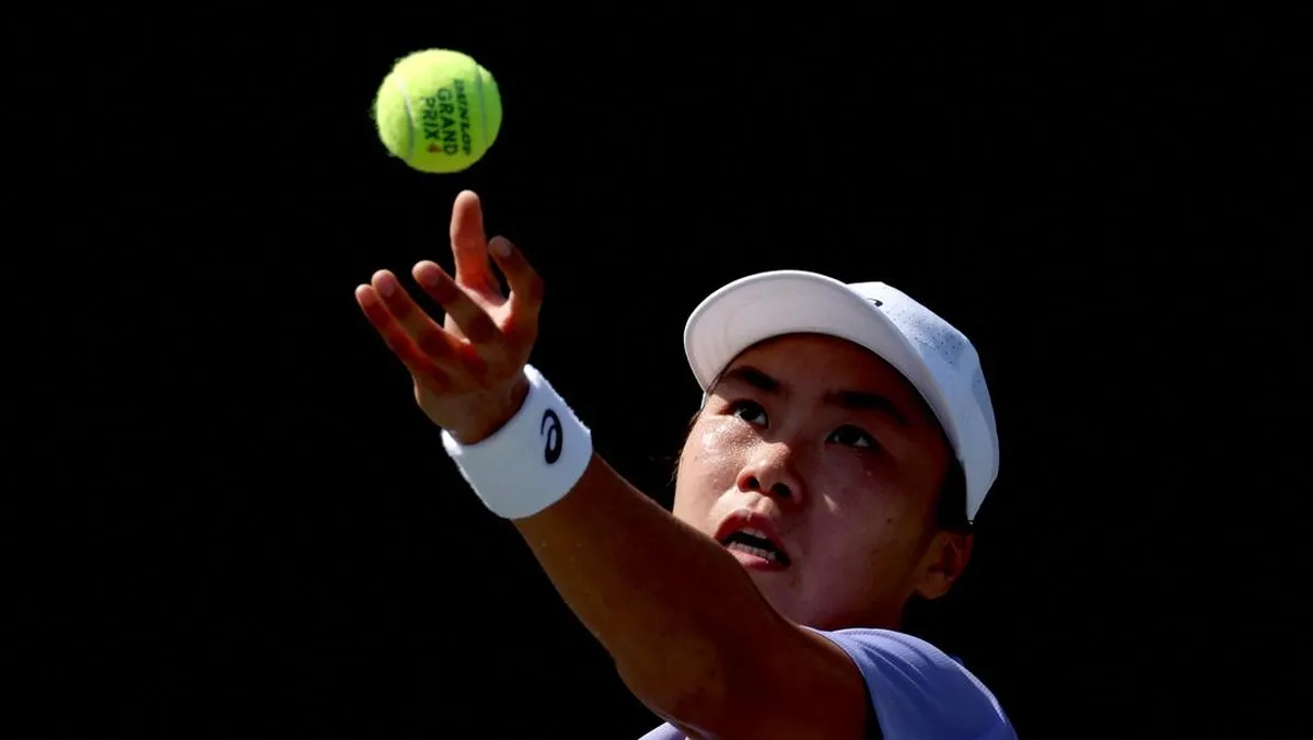 Tennis racket and balls beside the baseline of a hard court