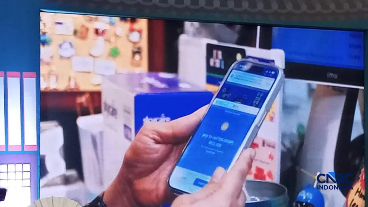Smartphone beside a QR payment code at a shop counter
