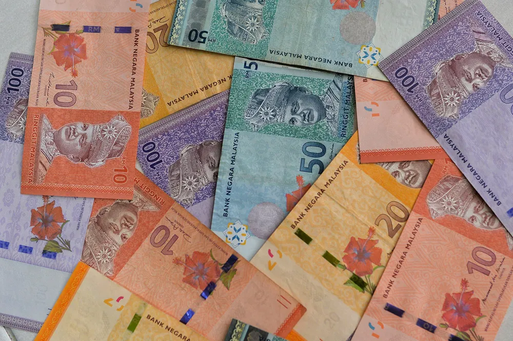 Malaysian ringgit banknotes beside US dollar notes