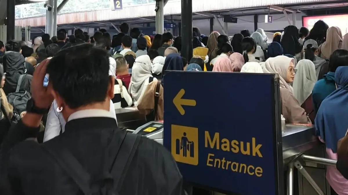 Commuter train beside a railway station platform in Indonesia