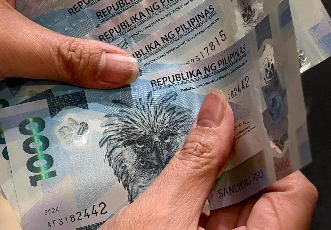 Philippine peso banknotes beside US dollar banknotes