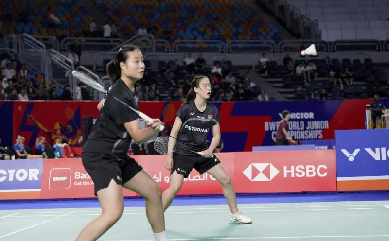 Badminton rackets and a shuttlecock beside a court