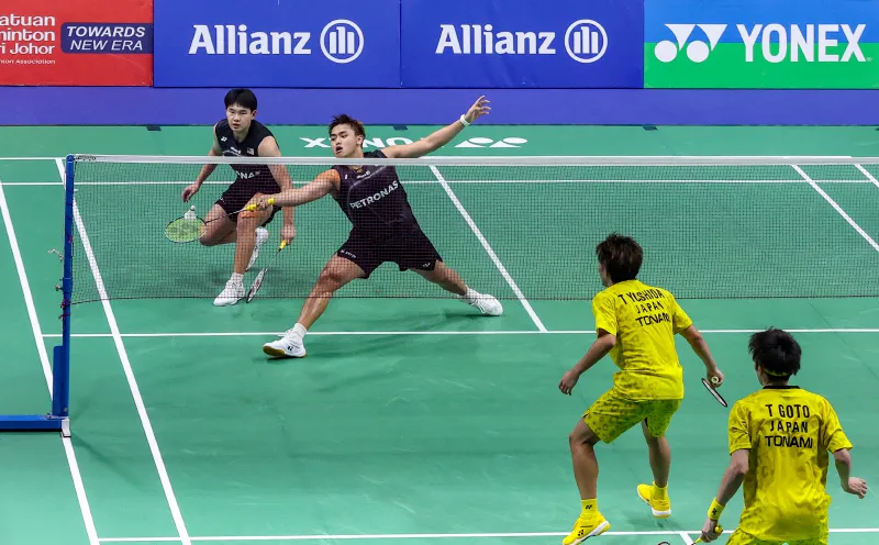 Shuttlecock beside a racket on an indoor badminton court