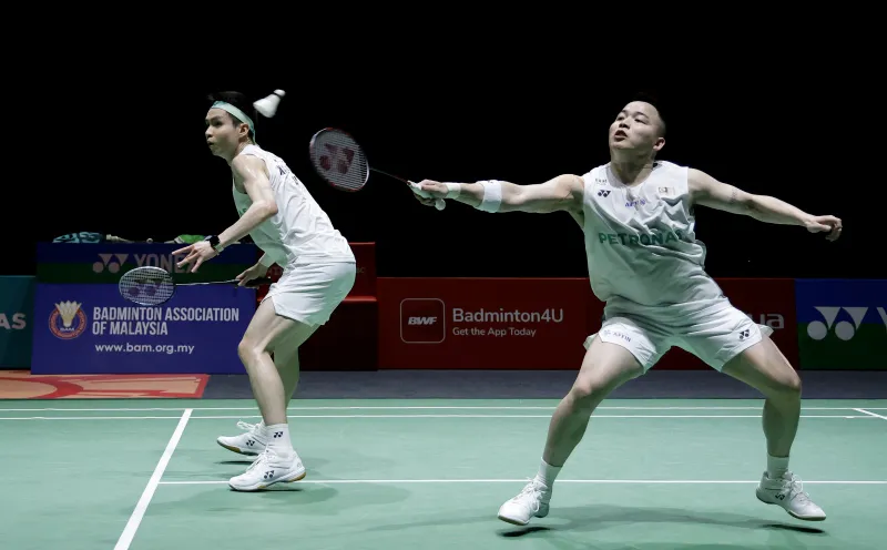 Badminton rackets and shuttlecocks beside a court