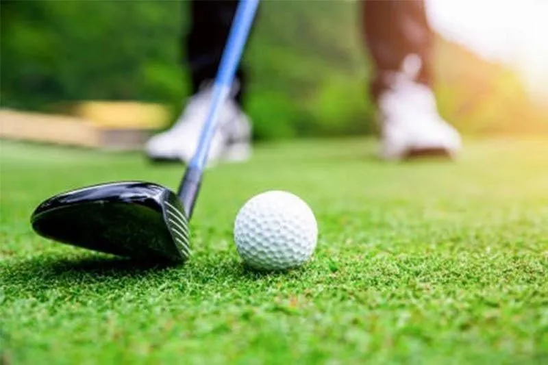 Golf ball beside a hole on a putting green