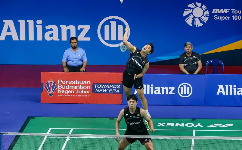 Shuttlecock and badminton rackets beside an indoor court