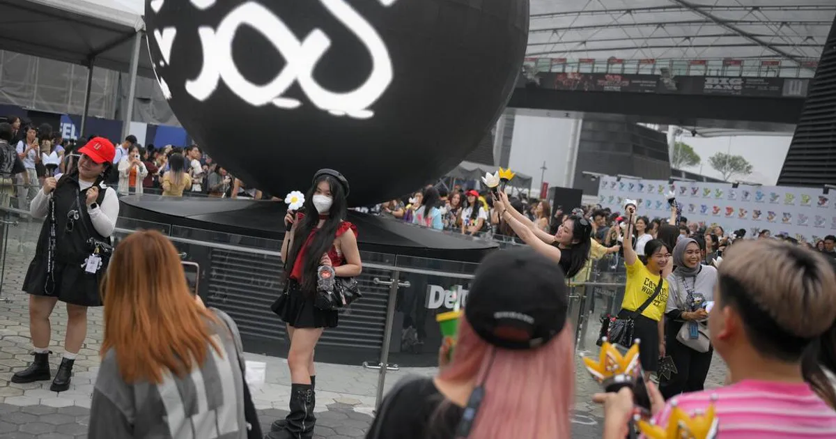 Concert light sticks held above a stadium crowd