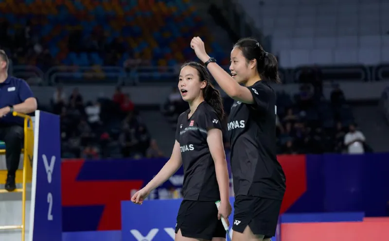 Badminton rackets and a shuttlecock beside a court