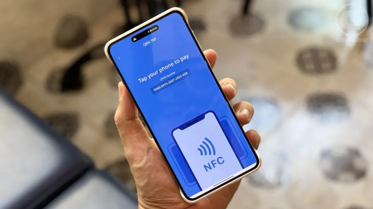 Smartphone beside a QR payment code at a checkout counter
