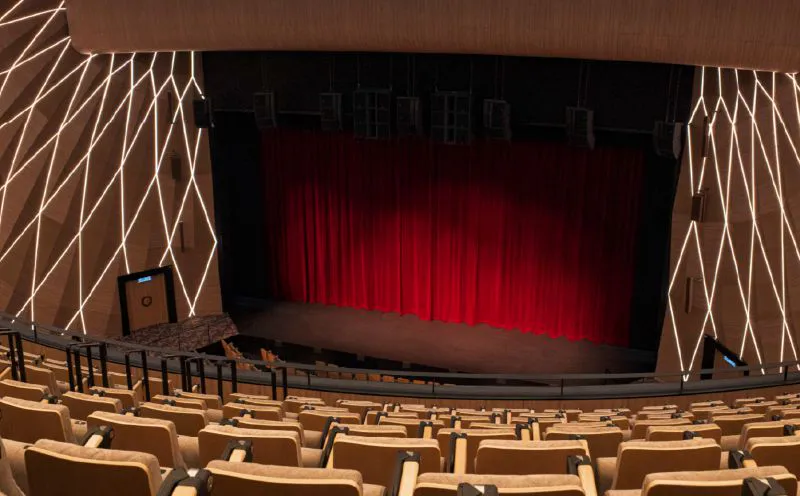 An auditorium with rows of seats facing a theatre stage