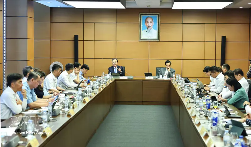 A meeting room with rows of desks and microphones