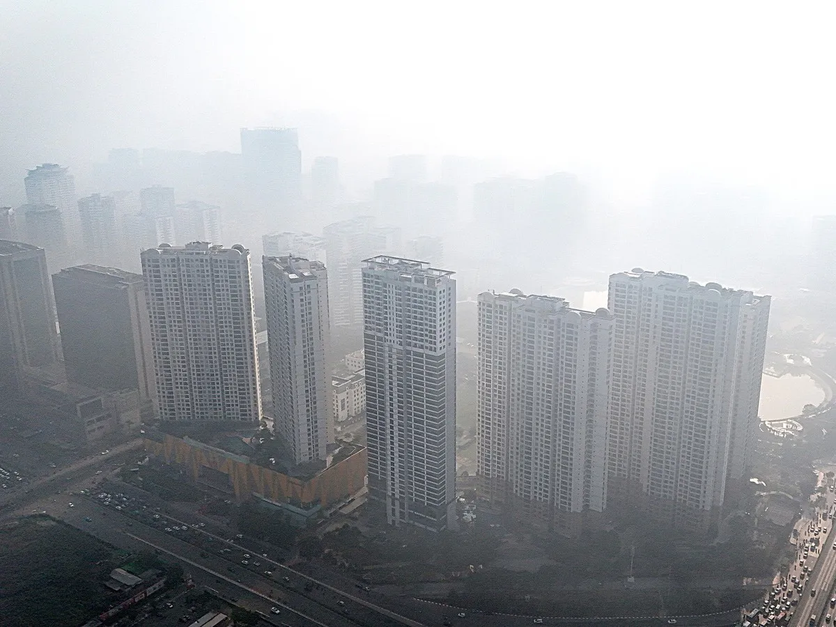 Illustration of urban buildings and traffic beneath a hazy sky