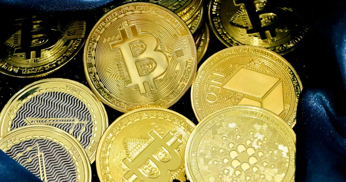 Digital tokens beside a computer displaying financial transactions