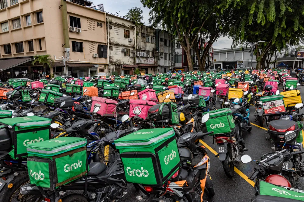 Motorcycle with an insulated food delivery bag parked beside a road