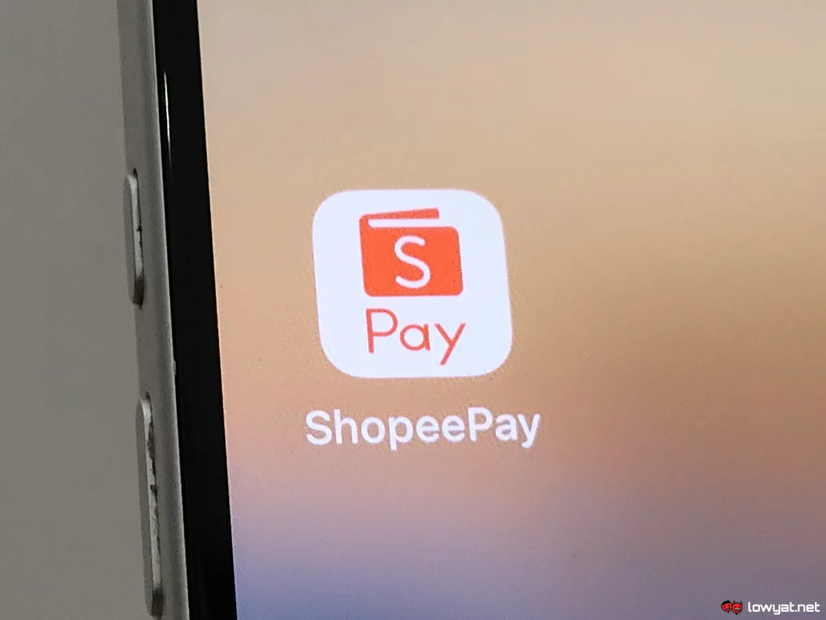 Smartphone beside Malaysian ringgit banknotes