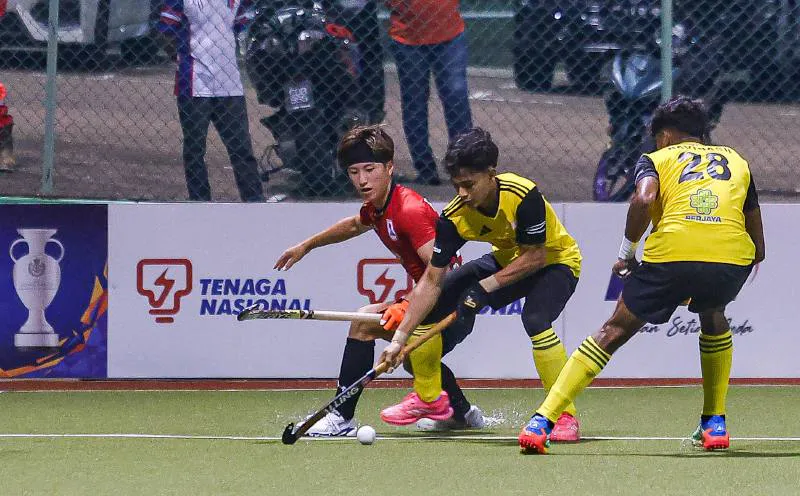 Hockey sticks and a ball on an artificial turf pitch