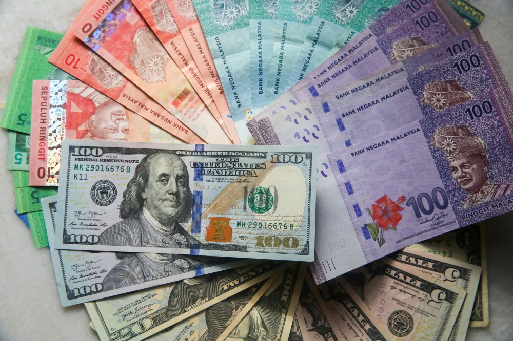 Malaysian ringgit banknotes beside US dollar notes