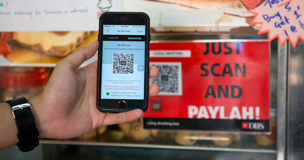 Smartphone beside a merchant QR payment code
