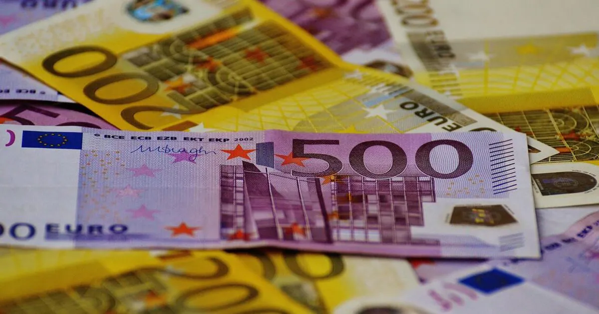 Euro banknotes beside Singapore dollar banknotes
