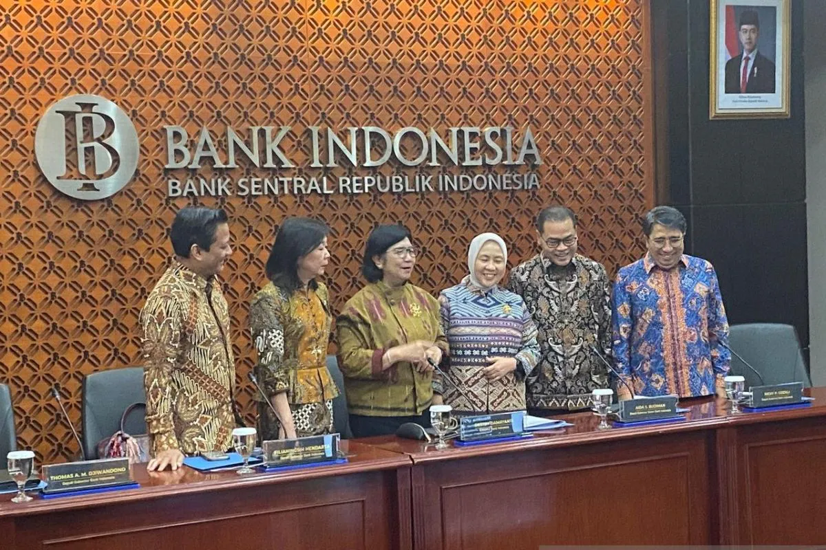 Indonesian rupiah banknotes beside a financial market chart