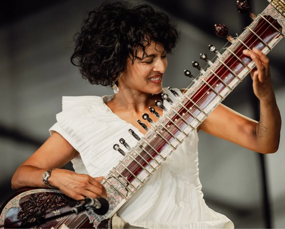 A sitar resting on an empty concert stage