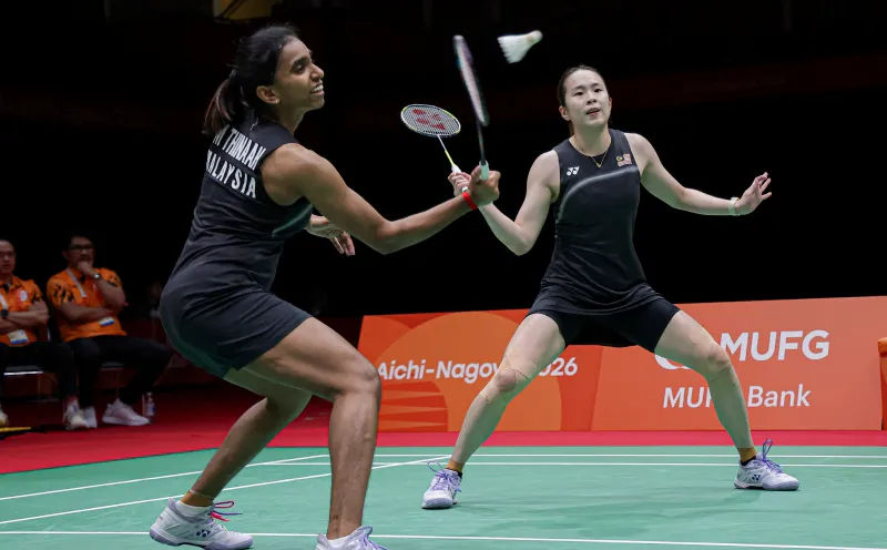 Badminton rackets and shuttlecocks beside an indoor court