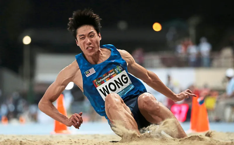 Long jump sandpit beside an athletics runway