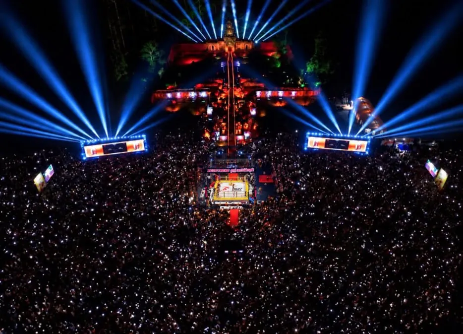 A combat sports ring illuminated for an outdoor evening contest