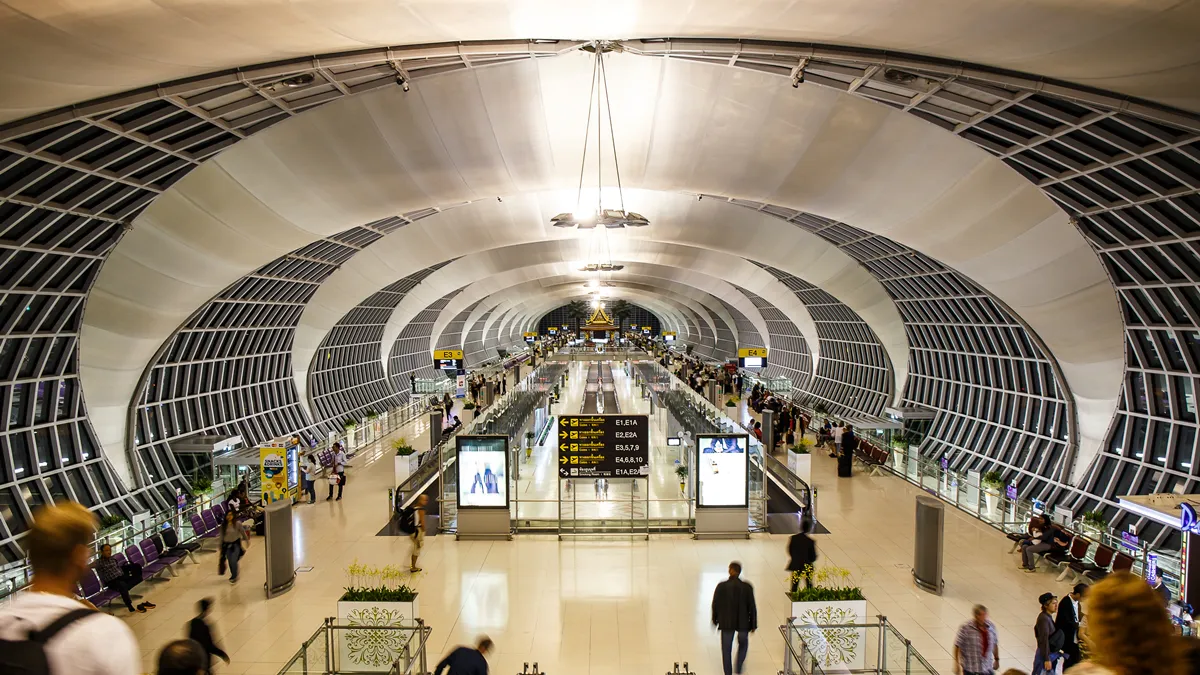 Departure boards and passenger seating inside an airport terminal