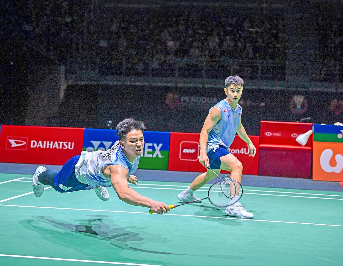 Badminton rackets and shuttlecocks beside an indoor doubles court