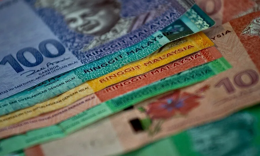 Malaysian ringgit banknotes beside a bank card