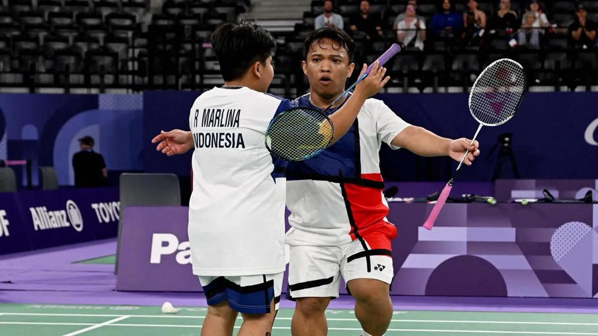 Badminton rackets and a shuttlecock beside a court