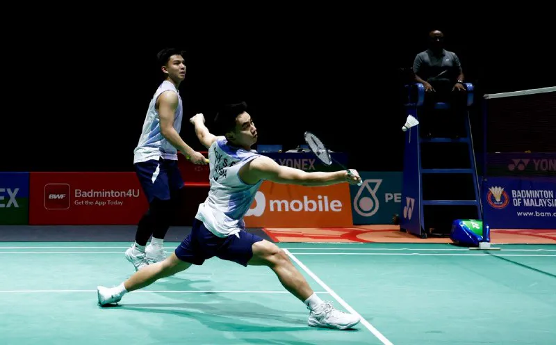 Badminton rackets and a shuttlecock beside a court