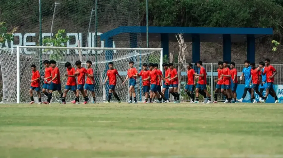 Football on a pitch beside a goal net