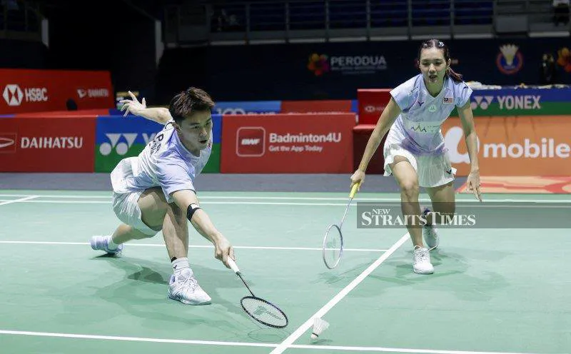 Badminton rackets and a shuttlecock beside a court