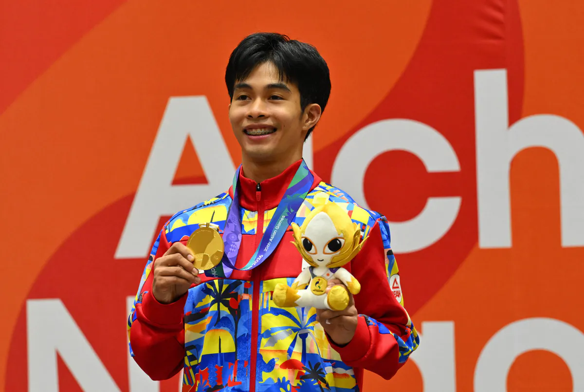 Gold and bronze sports medals beside a taekwondo uniform
