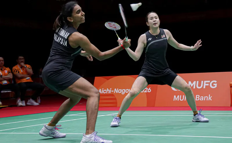 Badminton rackets and a shuttlecock beside a court