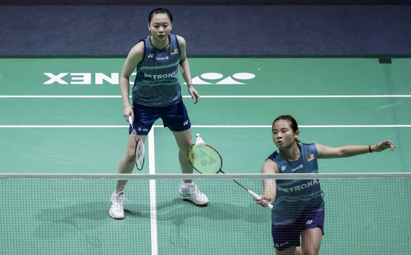 Shuttlecock beside a racket on an indoor badminton court