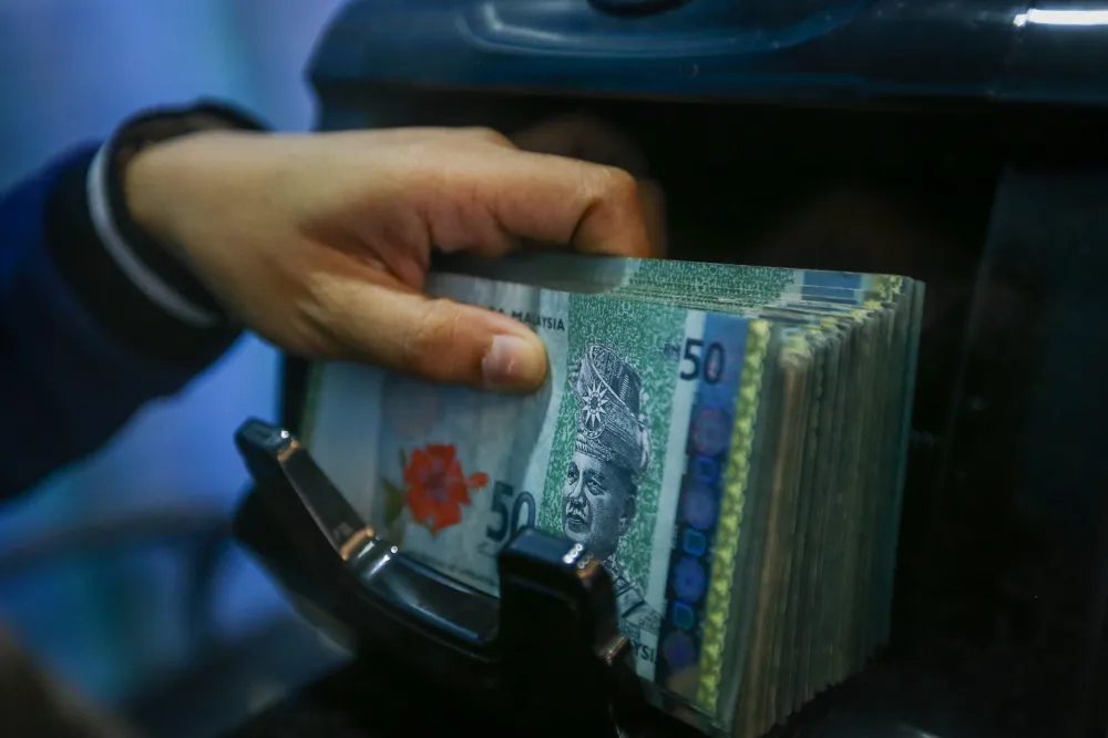 Malaysian ringgit banknotes beside US dollar notes