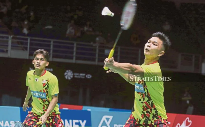 Badminton rackets and shuttlecocks beside a doubles court