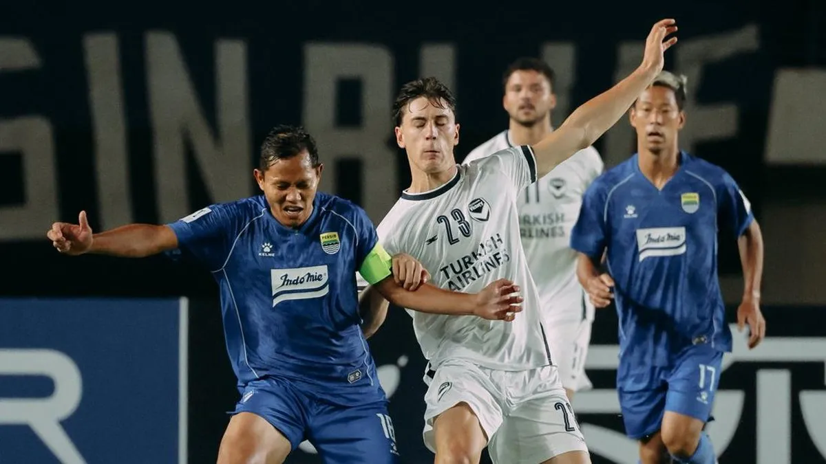 Football on a pitch beneath stadium floodlights