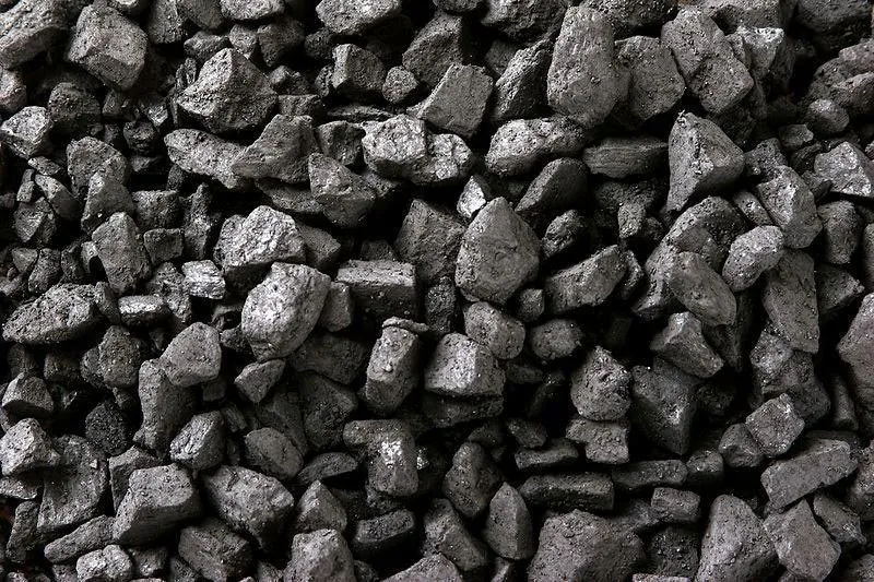 Coal stockpiles beside conveyor equipment at a shipping terminal