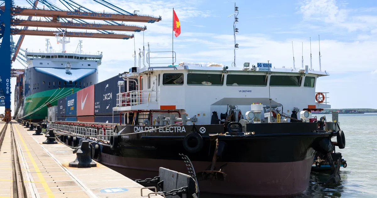 Container barge on an inland waterway near a cargo terminal