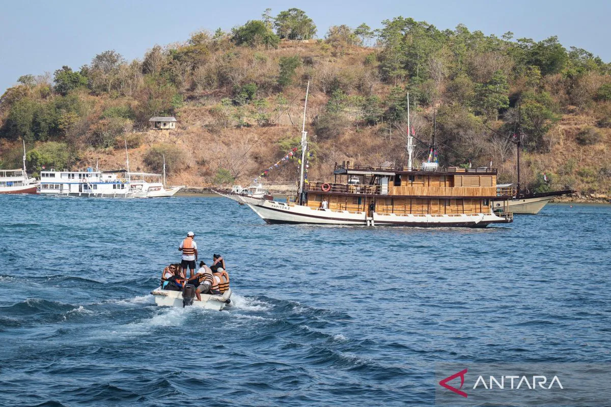 A traditional pinisi schooner sailing near islands in Indonesia