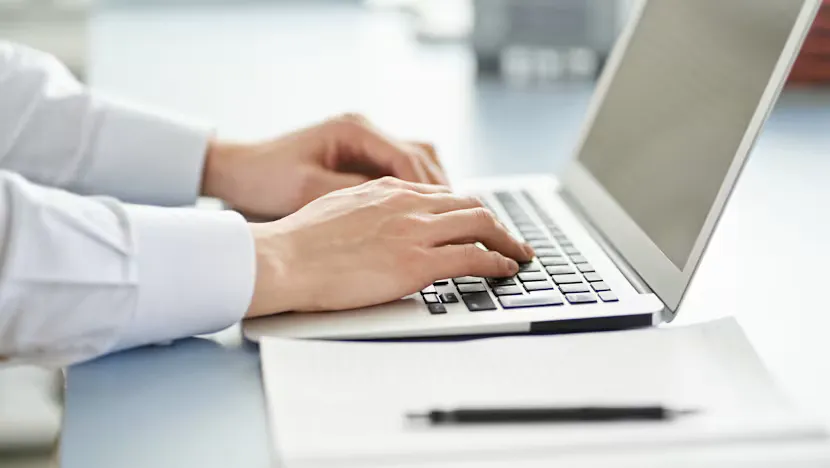 Computer and recruitment documents on an office desk