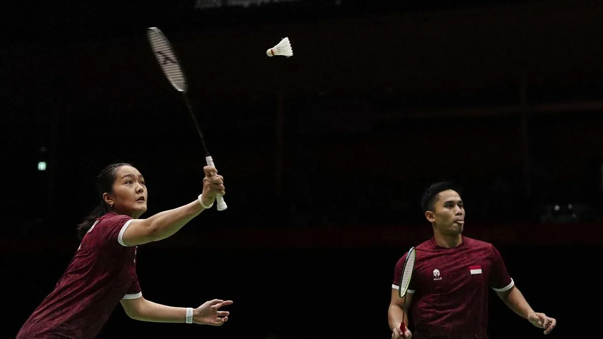 Badminton rackets and a shuttlecock beside a court
