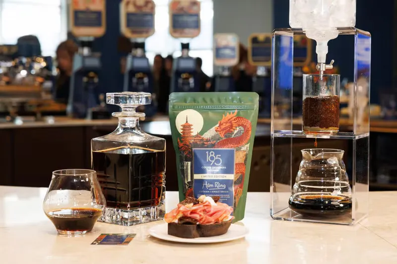 Roasted coffee beans beside a cup of black coffee